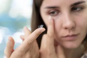 woman putting on contact lenses